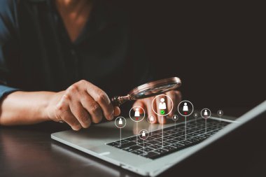 Adayları görüntülemek için dizüstü bilgisayar klavyesinin üzerine büyüteç kullanan, diğerlerini reddederken işaretli bir profili vurgulayan, dijital işe alma ve seçim simgesi.