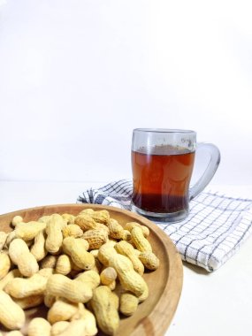 Tahta arka planda fıstıklı bir fincan sıcak kahve, seçici odaklı.