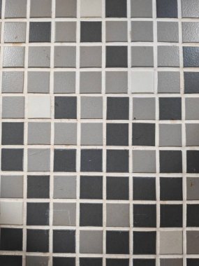 Beyaz harç çizgileri ile kare gri fayanslar geometrik dekoratif yüzey oluşturur.