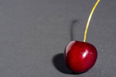 Parlak sulu, olgun vişne böğürtleni koyu bir arka planda izole. Boşluğu kopyala