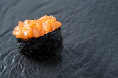 Siyah desenli yüzeyde kıymalı somon balığı. Yan görüntüyü yakından çek. Japon mutfağı.