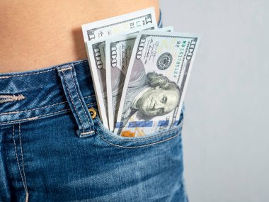 Kotunun ön cebinden 100 banknot çıkıyor. Cebindeki para konsepti.