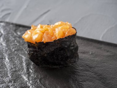 Siyah desenli yüzeyde kıymalı somon balığı. Yan görüntüyü yakından çek. Japon mutfağı.