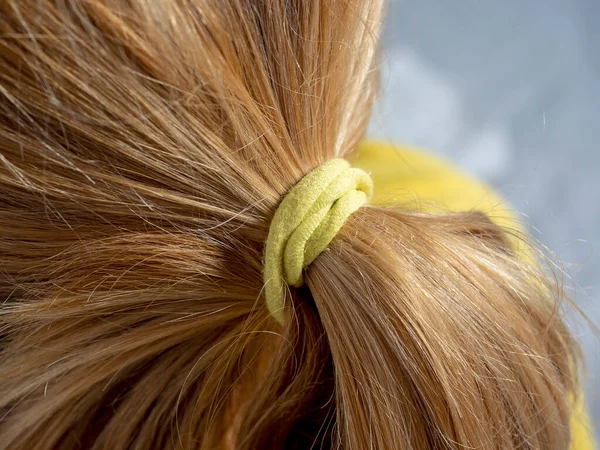 Close Cabelo Loiro Amarrado Pão Com Uma Faixa Elástica Amarela — Fotografia de Stock