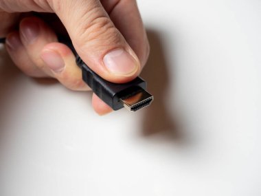 Adamın elinde siyah bir Hdmi kablosu var. ev ortamını bağlamak için kablo