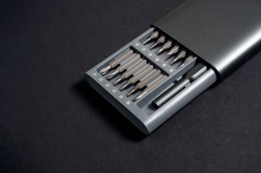 Karanlık bir arka planda, içinde bit olan bir tornavida seti. Kapatın, iş için.