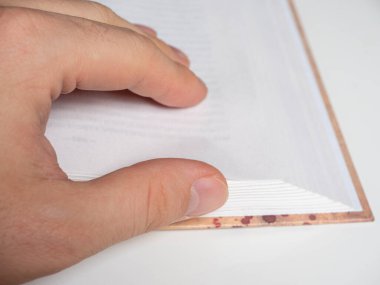 Bir adamın eli yakın planda boş bir sayfayı çevirir. Seçici Odaklanma