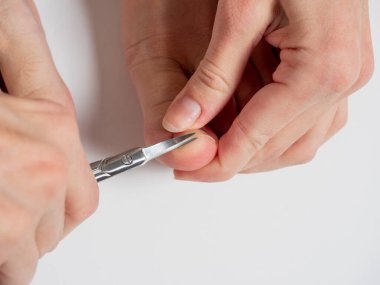 Makas, bir kadının ayak başparmağının tırnaklarını kesmiş. Çivi ve ayak bakımı kavramı. seçici odak