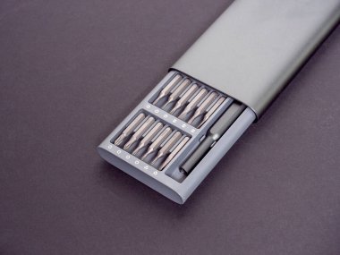 Karanlık bir arka planda, içinde bit olan bir tornavida seti. Kapatın, iş için.