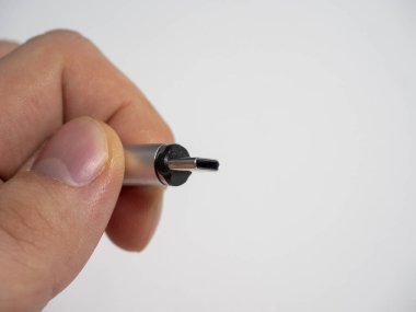 USB tip C kablosu, beyaz arka planda insan elinde manyetik bir eklenti ile katlanabilir. Boşluğu kopyala