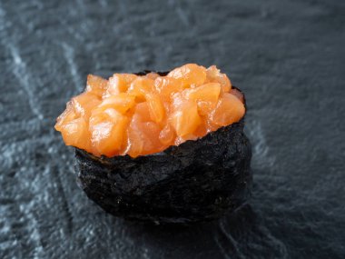 Siyah desenli yüzeyde kıymalı somon balığı. Yan görüntüyü yakından çek. Japon mutfağı.