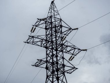 Güç kulesi kışın gri gökyüzüne yakın çekim yapıyor. Güç iletimi ve iletişim teknolojileri. yatay resim