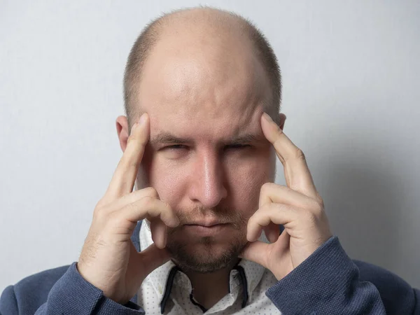 the middle-aged man in the suit put his fingers to his head and squinted. Focused, trying to remember. male portrait, emotions, idea