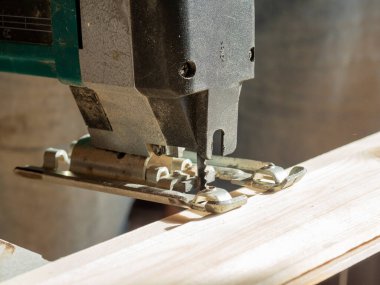 Tahta bir tahtayı kesecek elektrikli yapboz. Bıçağa yakın çekim. Seçici odak