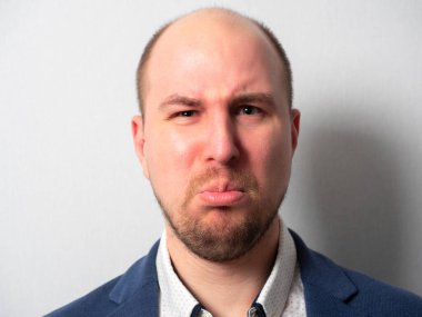 Takım elbiseli orta yaşlı bir adamın portresi. İncinmiş bir ifade. Duygular. Alt dudağını yuvarladı.