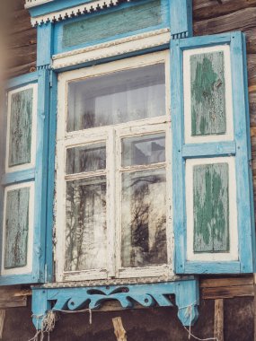 Mavi panjurlu bir pencerenin yakın çekimi. Eski kırsal mimari, dekor, klasik