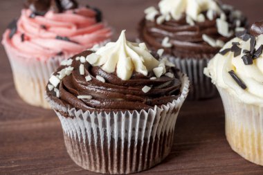 Tahta arka planda tatlı, lezzetli ve yüksek kalorili çikolatalı kek. Yemek kompozisyonu, tatlılık, cazibe, abur cubur.