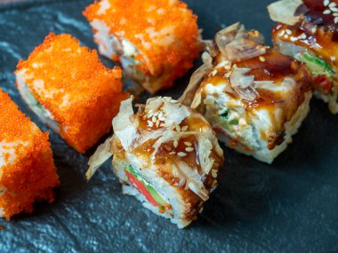 Havyarla süslenmiş lezzetli ekmeklerin yan görüntüsü. Japon mutfağı, siyah tabak, yakın çekim.