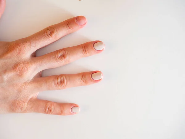 Kvinnas Hand Med Delvis Målade Naglar Vit Bakgrund Begreppet Manikyr — Stockfoto