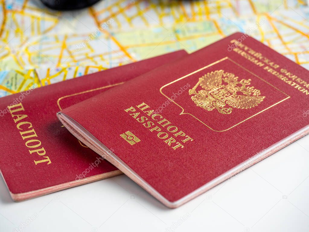 close-up of two Russian passports lying on the map of the city. The concept of travel and migration