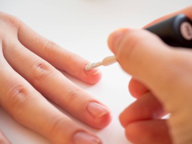 Tırnağa beyaz oje sürüyorum. Manikür ve tırnak bakımı kavramı