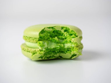 Yeşil renkli yuvarlak badem kurabiyeler, beyaz arka planda ısırılmış. Tatlı, lezzetli tatlı. Minimalizm. Yan görünüm