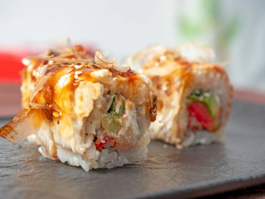 Siyah bir tabakta suşi rulosunun yakın çekimi. Geleneksel Japon mutfağı