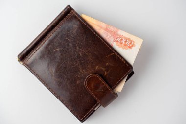 5000 ruble 'lik deri bir cüzdanın yakın plan resmi beyaz arka planda duruyor. Üst manzara, düz uzanma