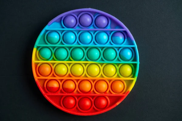 the Pop it fidget toy on a black background. top view, flat lay. anti-stress toy