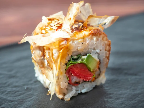 Siyah bir tabakta suşi rulosunun yakın çekimi. Geleneksel Japon mutfağı