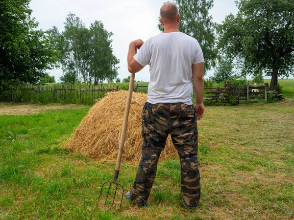 Man Stands His Back Camera Pitchfork Front Haystack Rural Landscape Stock Picture