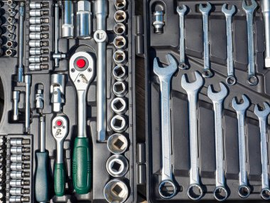 Çantanın içinde çeşitli aletler var. Yakından, üstten, düz.