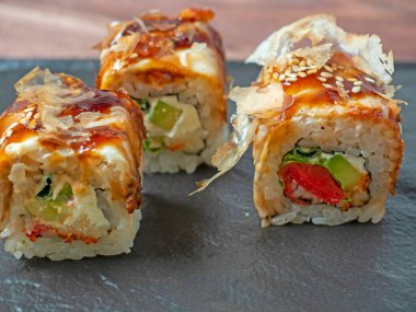 Siyah bir tabakta suşi rulosunun yakın çekimi. Geleneksel Japon mutfağı