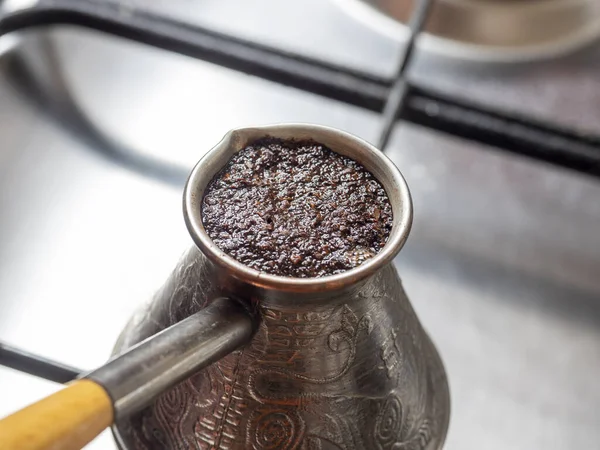 Kahve gaz ocağında bakır bir Türk 'te demlenir. Konsept kahvaltı, sabah kahvesi.