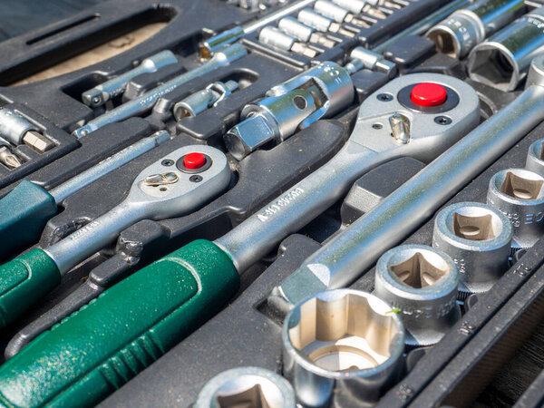 A close-up of a set of tools for repairing a car and other things. wrenches, bits, attachments. Side view