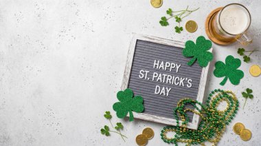 Aziz Patrick Günü için bir şenlik düzenleme, bir mektup tahtası, yoncalar, altın paralar ve dokulu bir arka planda bir bardak bira..