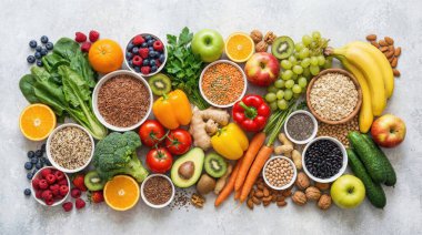 Taze meyve, sebze, tahıl ve fındık çeşitlerinin canlı bir genel çekim, titizlikle hafif bir arka planda düzenlenmiş, sağlıklı beslenme ve dengeli bir diyet teşvik.