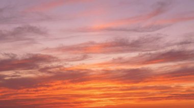 Nefes kesici bir günbatımı gökyüzünü çarpıcı turuncu, yumuşak pembe ve derin mor renklerle boyar dramatik ve sakin doğal bir zemin oluşturur..
