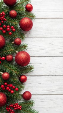 Parlak kırmızı mücevherler ve böğürtlenlerle bezenmiş yemyeşil köknar dallarının yer aldığı güzel bir Noel arkaplanı, kırsal beyaz ahşap yüzeye kurulmuş, neşeli ve rahat bir tatil atmosferi yaratıyor..