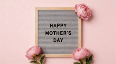 Gri keçeli bir mektup panosunun üzerinde üç tane yumuşak pembe şakayık çiçeğiyle çerçevelenmiş ve süslenmiş içten bir Mutlu Anneler Günü mesajı. Düzenleme yumuşak, açık pembe bir zemine göre ayarlandı. Güve için tatlı ve sevgi dolu bir övgü oluşturuldu.