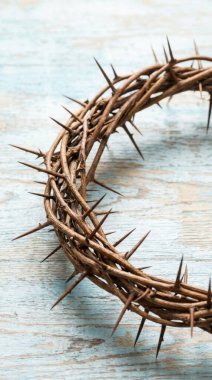 Dikenli bir taç, acı ve fedakarlığın sembolü, kırsal, açık mavi ahşap bir yüzeye dayanır, Paskalya ve dini bağlılık temalarını çağrıştırır..