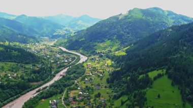 Ukrayna 'nın dik Karpat dağlarındaki Terebovlia köyü ve dolambaçlı nehir manzarası. Yüksek kaliteli FullHD görüntüler