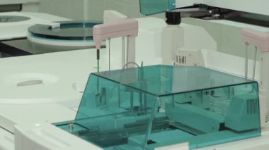 Biyokimyasal ve klinik teşhisler için tıbbi laboratuvarlarda kullanılan yüksek teknolojili bir analizci. Görüntü, steril bir ortamda profesyonel tıbbi ekipmanların robot kolu ve örnek işleme birimini gösteriyor..