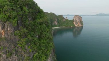 Tayland 'ın Phang Nga körfezinde Koh Hong' un hava görüntüsü, insansız hava aracı beyaz kumlu kumsalı ortaya çıkarmak için kireçtaşlı dağların üzerinden uçuyor..