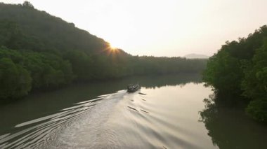 Yoğun yeşil mangrov ormanlarından akan sarmal nehrin hava manzarası sabah güneşi tepenin üstünden yükselirken, sisli gökyüzünün altında, Tayland 'ın Koh Yao Yai kentindeki sakin tropikal doğa manzarası..