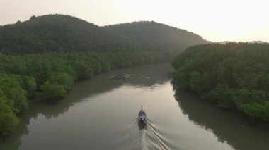 Yoğun yeşil mangrov ormanları boyunca sarmal nehir manzarası. Tepeler ve yüzen ahşap balıkçılık platformları. Puslu gökyüzü altında, sakin tropikal doğa Koh Yao Yai, Tayland.
