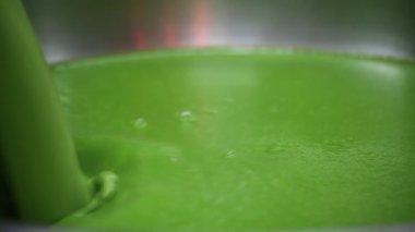 Yeşil çorba yeşil sıvı tencereye dökülüyor.