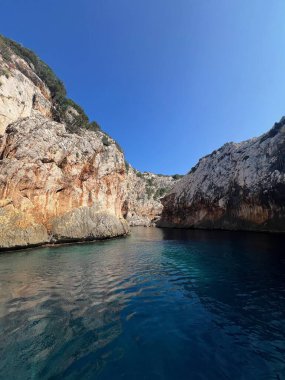 İtalya 'nın Sardunya sahilinde dramatik kireçtaşı uçurumları ve sakin mavi suları olan gizli deniz kanyonu. Manzaralı Akdeniz deniz manzarası dokunulmamış doğa ve kıyı güzelliğini sergiliyor..