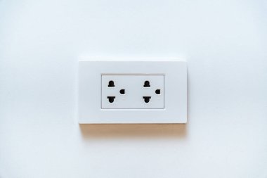 Temiz beyaz bir duvarda, fotokopi alanı olan çift prizli beyaz bir elektrik prizi. Güç kaynağı kavramı ve ev iç tasarımı.