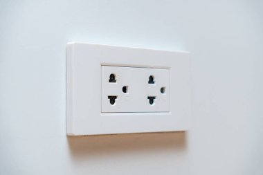Temiz beyaz bir duvarda, fotokopi alanı olan çift prizli beyaz bir elektrik prizi. Güç kaynağı kavramı ve ev iç tasarımı.